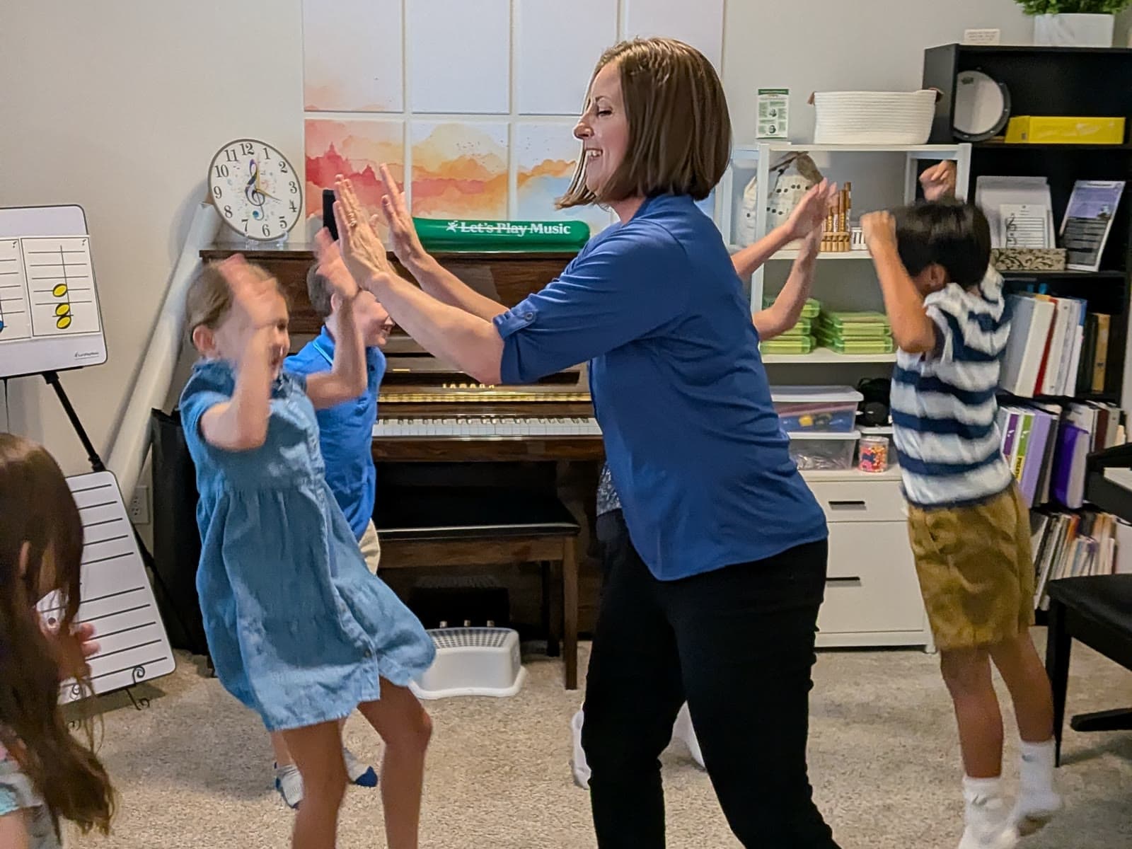 Ms. Shannon sharing a high five with a student during an active music lesson